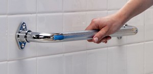 Barre d’appui striée chromée avec brides pivotantes, par AquaSense®, installée sur un mur dans une salle de bains.